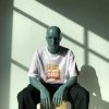 dramatic-light-and-shadow-tshirt-mockup-blue-mannequin-seated-on-box-in-modern-studio-with-window-reflections-01940 Customized Apparels